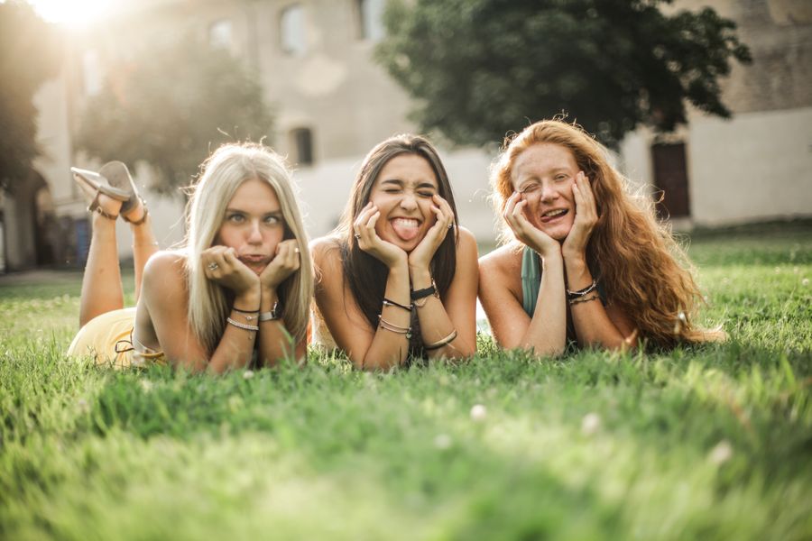 Friends relaxing together on the grass in the sunshine