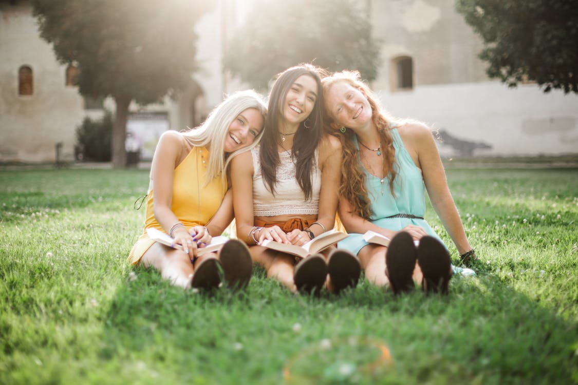 three women sitting on the grass