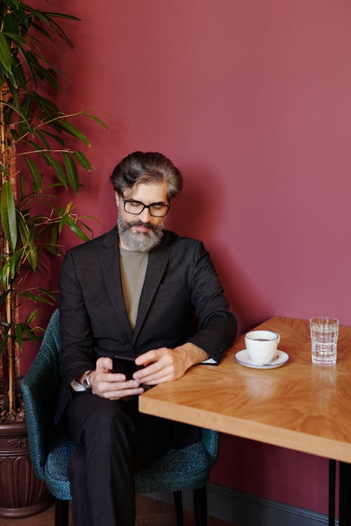 Elegant Man in a Suit Sitting in a Cafe with a Cup of Espresso 