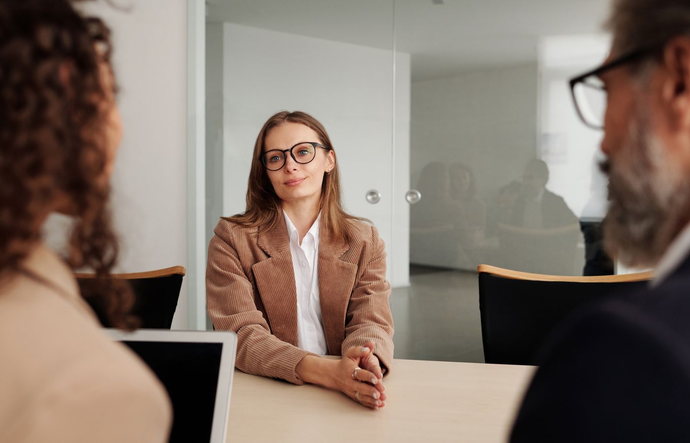 Young woman attending a job interview in a modern office, showcasing confidence and professionalism.