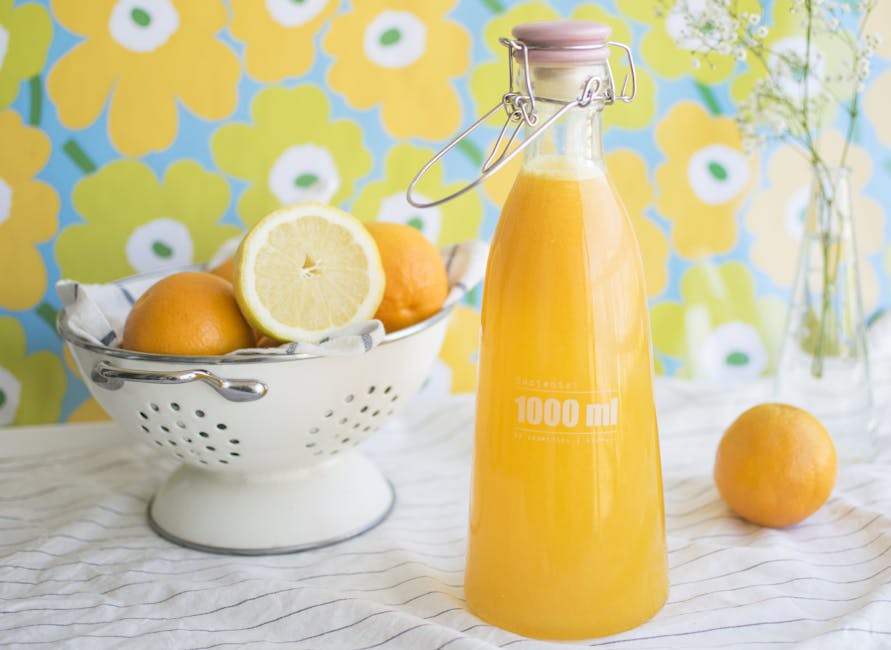 Orange Juice-filled Bottle Near Tray With Orange Fruits