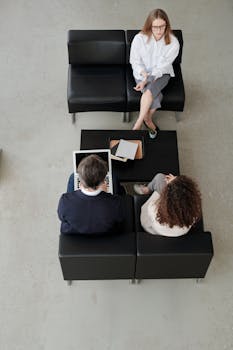 Overhead view of colleagues in a modern office, collaborating on laptops and notebooks.