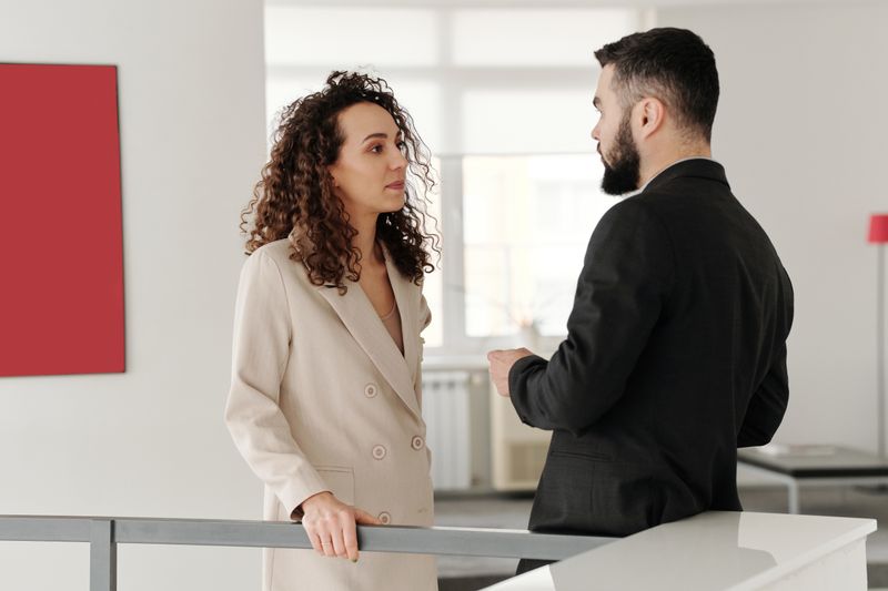 Two professionals engaged in a discussion in a bright modern office