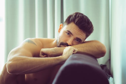 Free Topless Man Leaning on Sofa Stock Photo