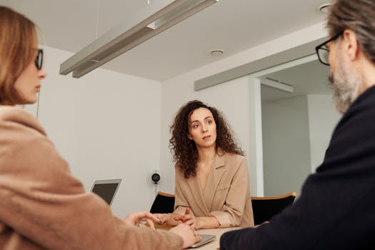Professionals engage in a focused discussion during a business meeting in a modern office setting.