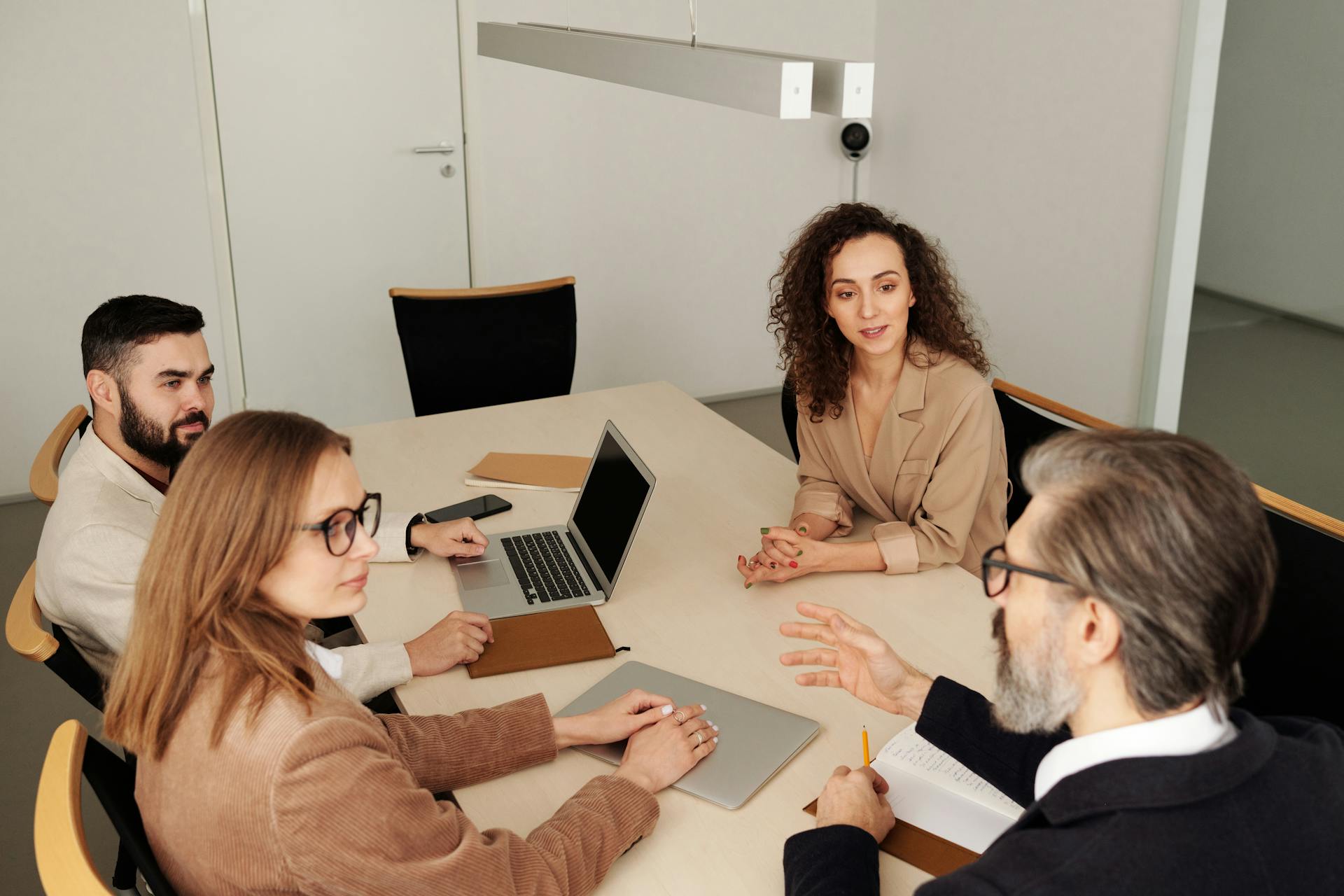 Professional team engaged in a meeting at a modern office table, discussing business strategies.