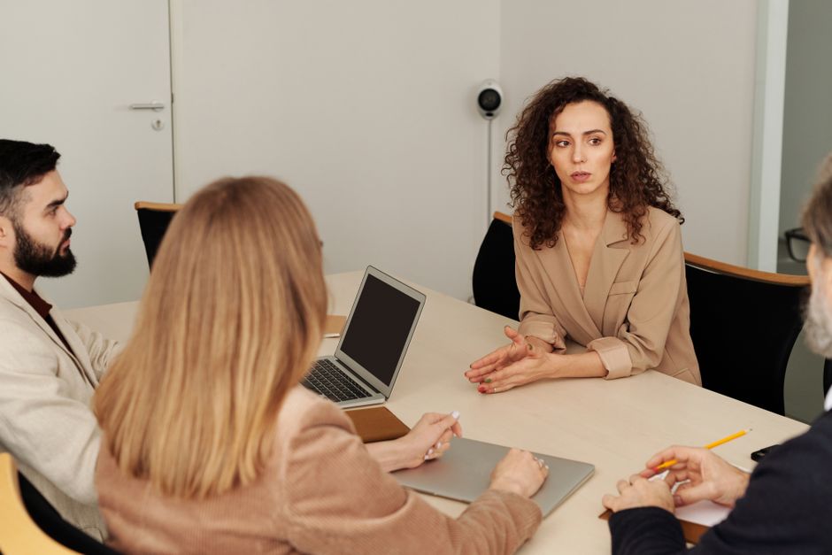 Un equipo diverso de profesionales participando en una reunión empresarial en un entorno de oficina moderno.