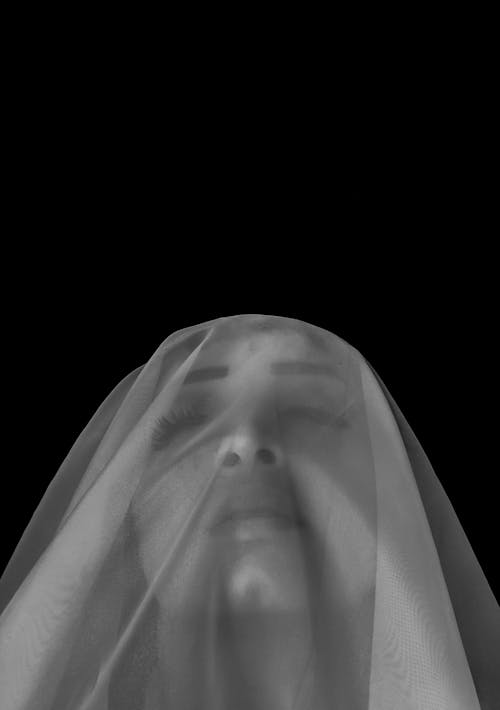 Unrecognizable woman under transparent veil
