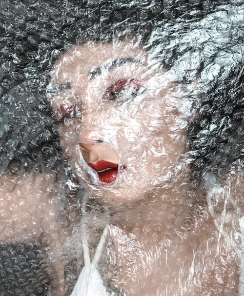 Unrecognizable woman under bubble wrap