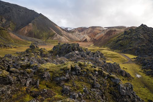 Spectacular valley located between mountains under cloudy sky in afternoon