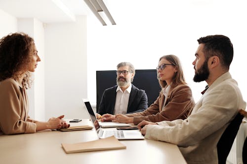 A Group of People Sitting at the Table at a Business Meeting 