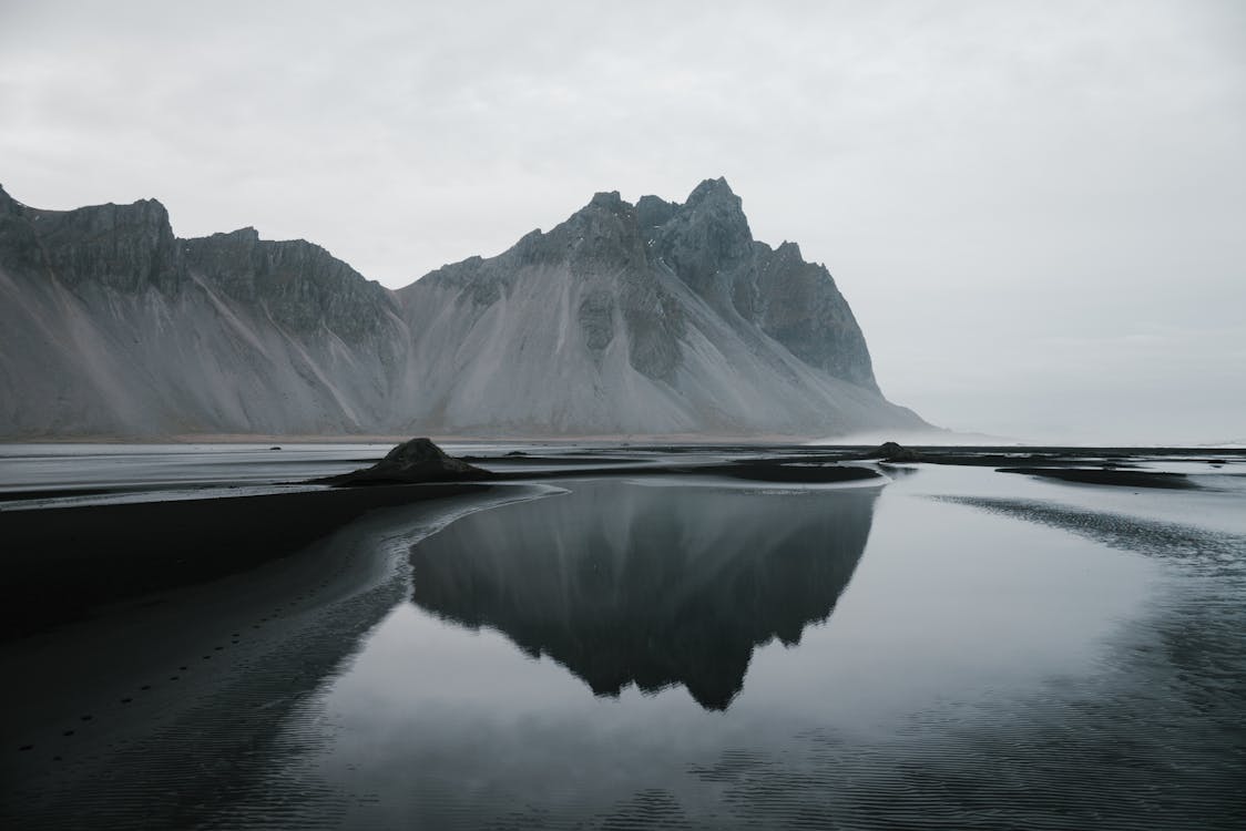 Free Peaceful cliffs across lake in cloudy day Stock Photo