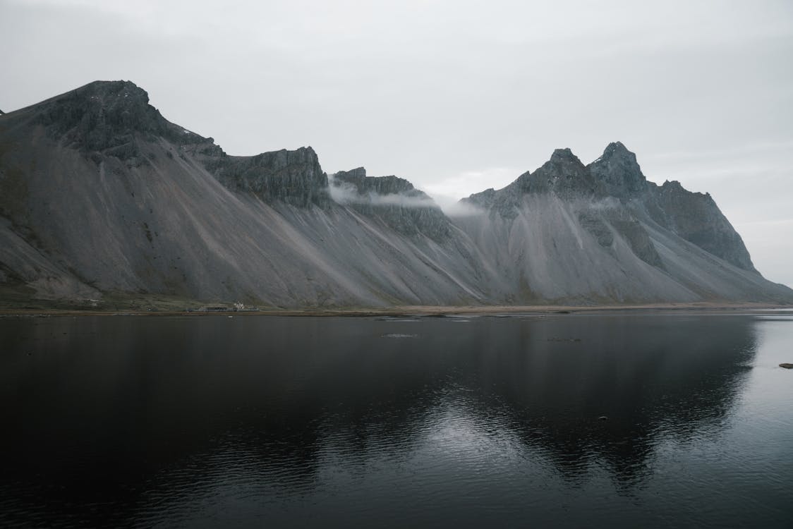 Free Lake Near Mountain Range Under White Sky Stock Photo