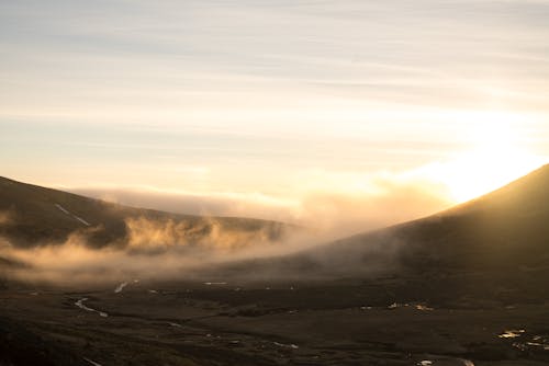 Fog above valley in highlands at sunrise
