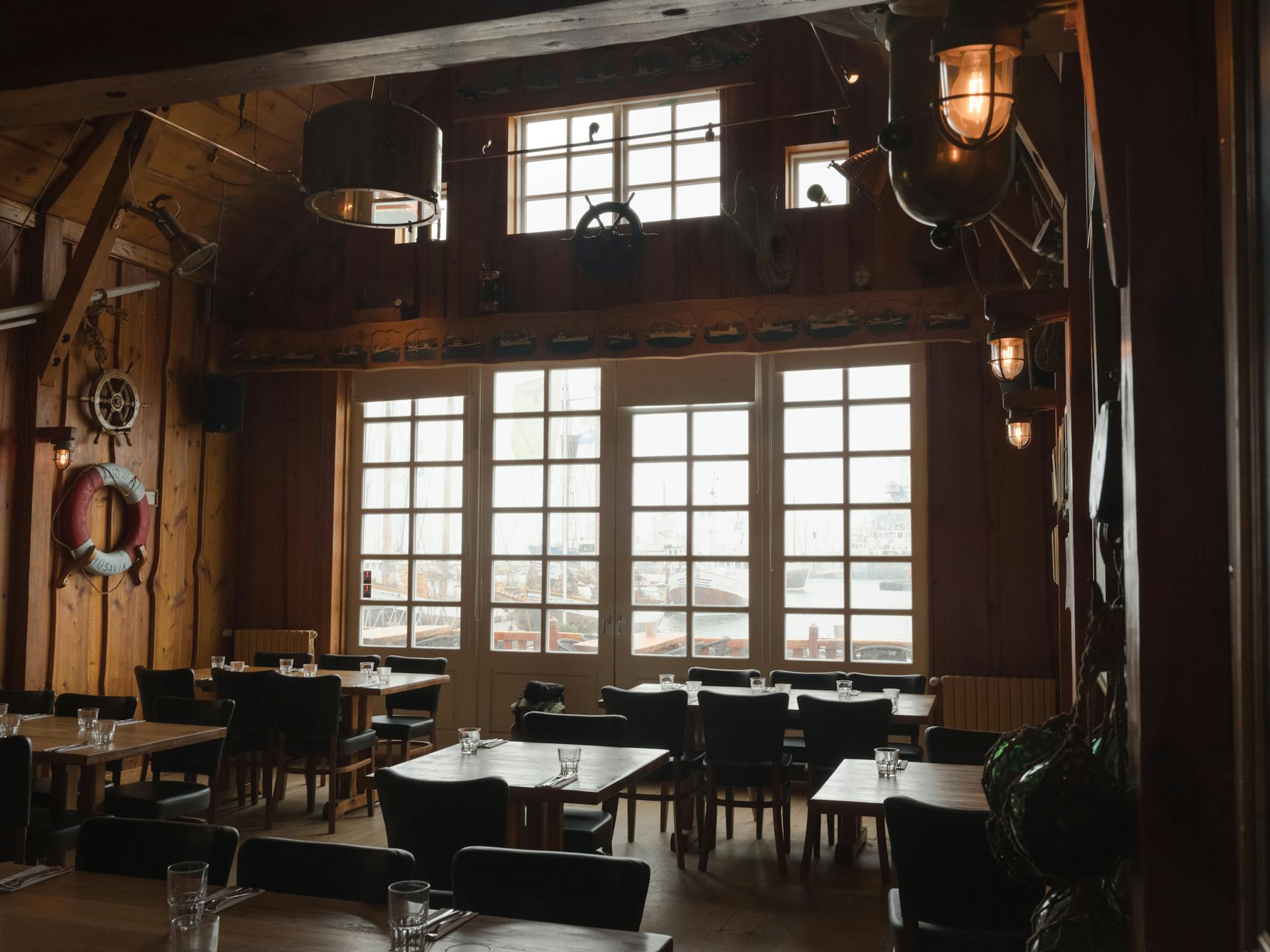 Warm and rustic interior of a nautical-themed restaurant with wooden decor and marine elements.