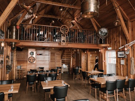 Cozy maritime-themed wooden interior of a rustic restaurant with seating area, evoking vintage charm.