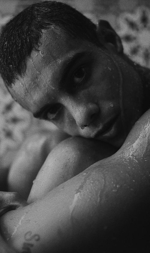 Free Moody black and white photo of a wet man gazing at the camera. Stock Photo