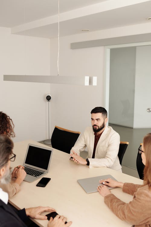 Free Man in White Suit Jacket Sitting Having an Interview Stock Photo