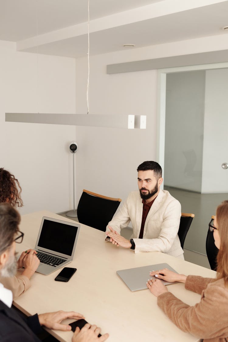 Man In White Suit Jacket Sitting Having An Interview