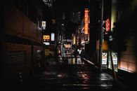 东京一条黑暗潮湿的小巷，夜晚被彩色标志照亮