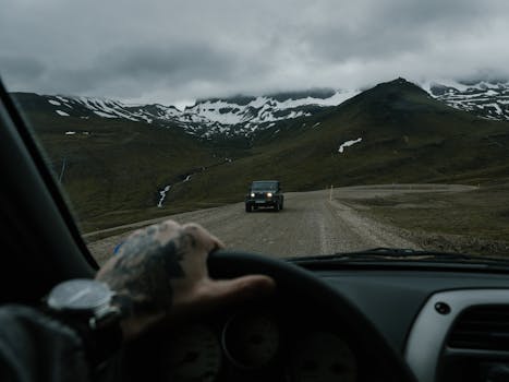 Exploring a mountainous landscape in an off-road vehicle on a cloudy day.
