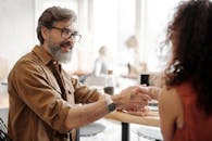 两名专业人士在办公室握手，象征着商业协议的达成