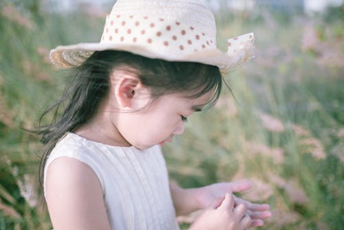 Little girl in hat in field