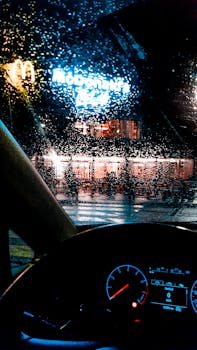 View of McDonald's through a rainy windshield at night.