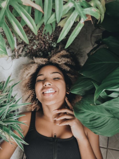 Free Cheerful woman resting in plant nursery Stock Photo