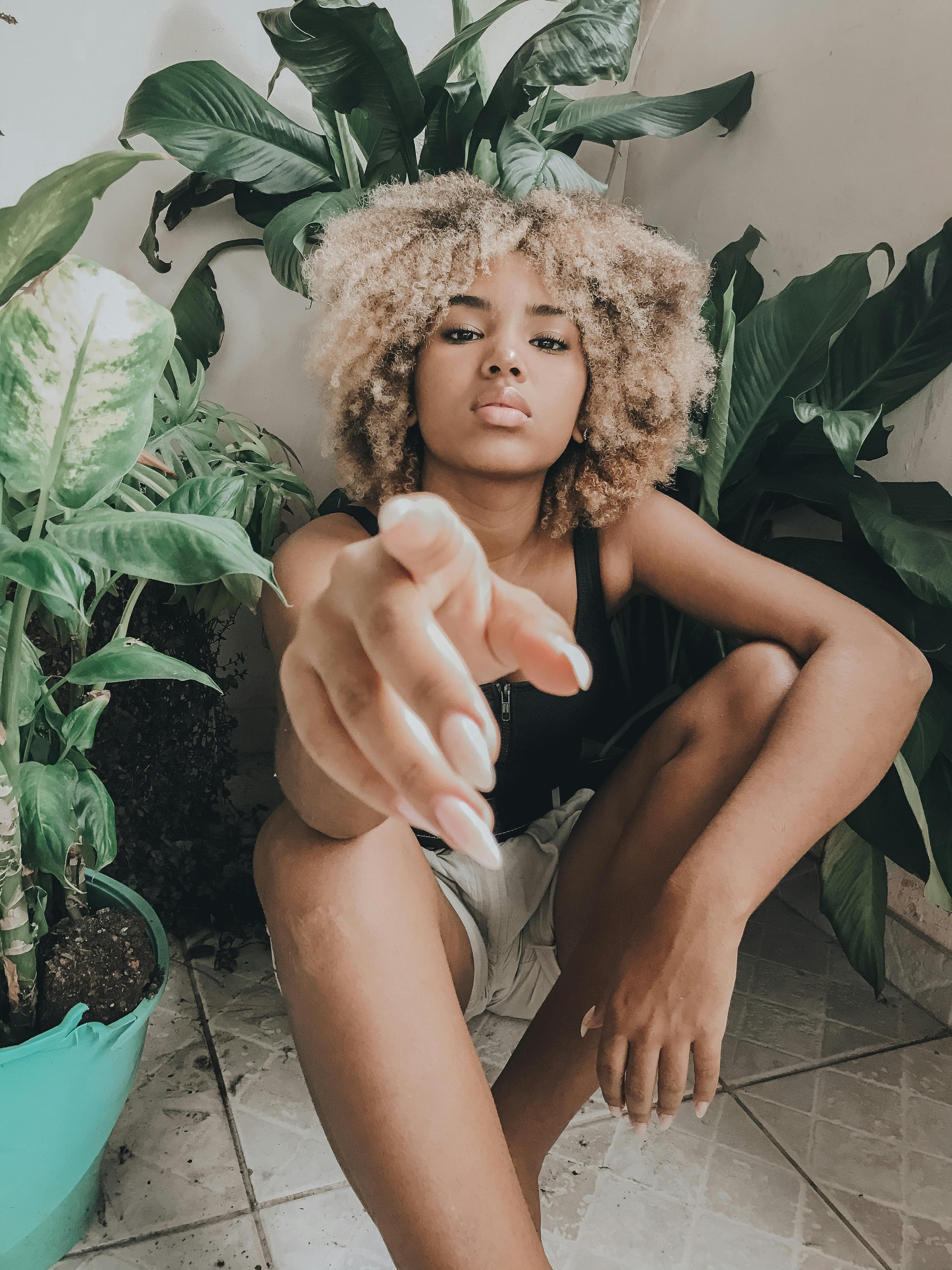 pensive woman pointing index finger at camera