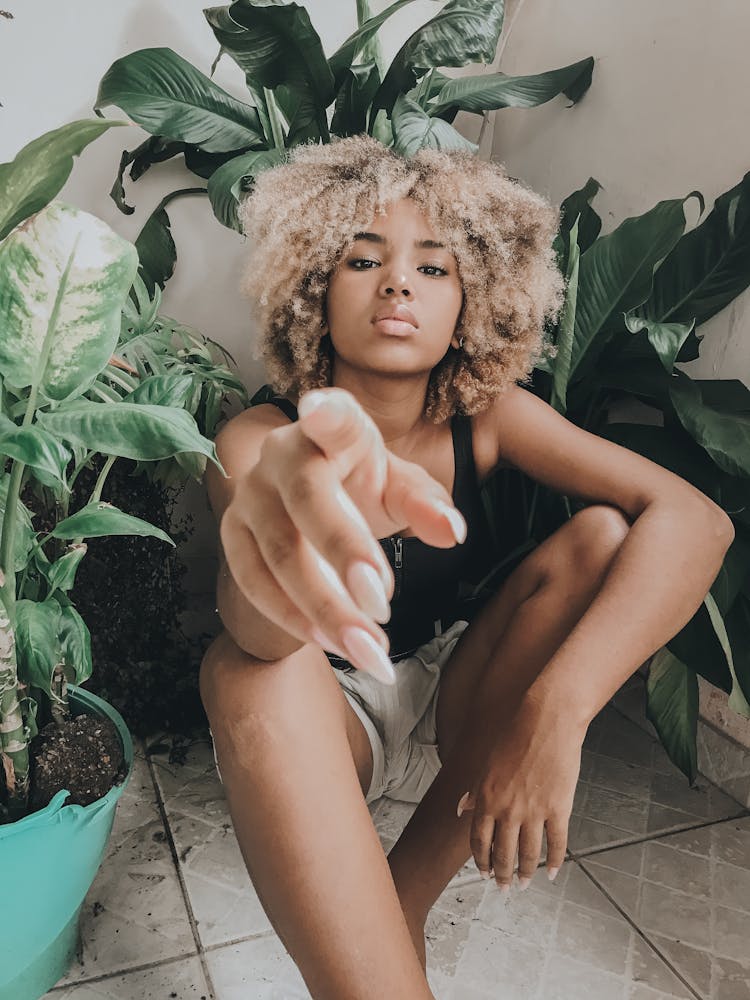 Pensive Woman Pointing Index Finger At Camera