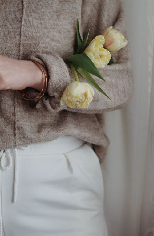 Free Unrecognizable female in casual wear standing with bunch of yellow tulips in modern apartment Stock Photo
