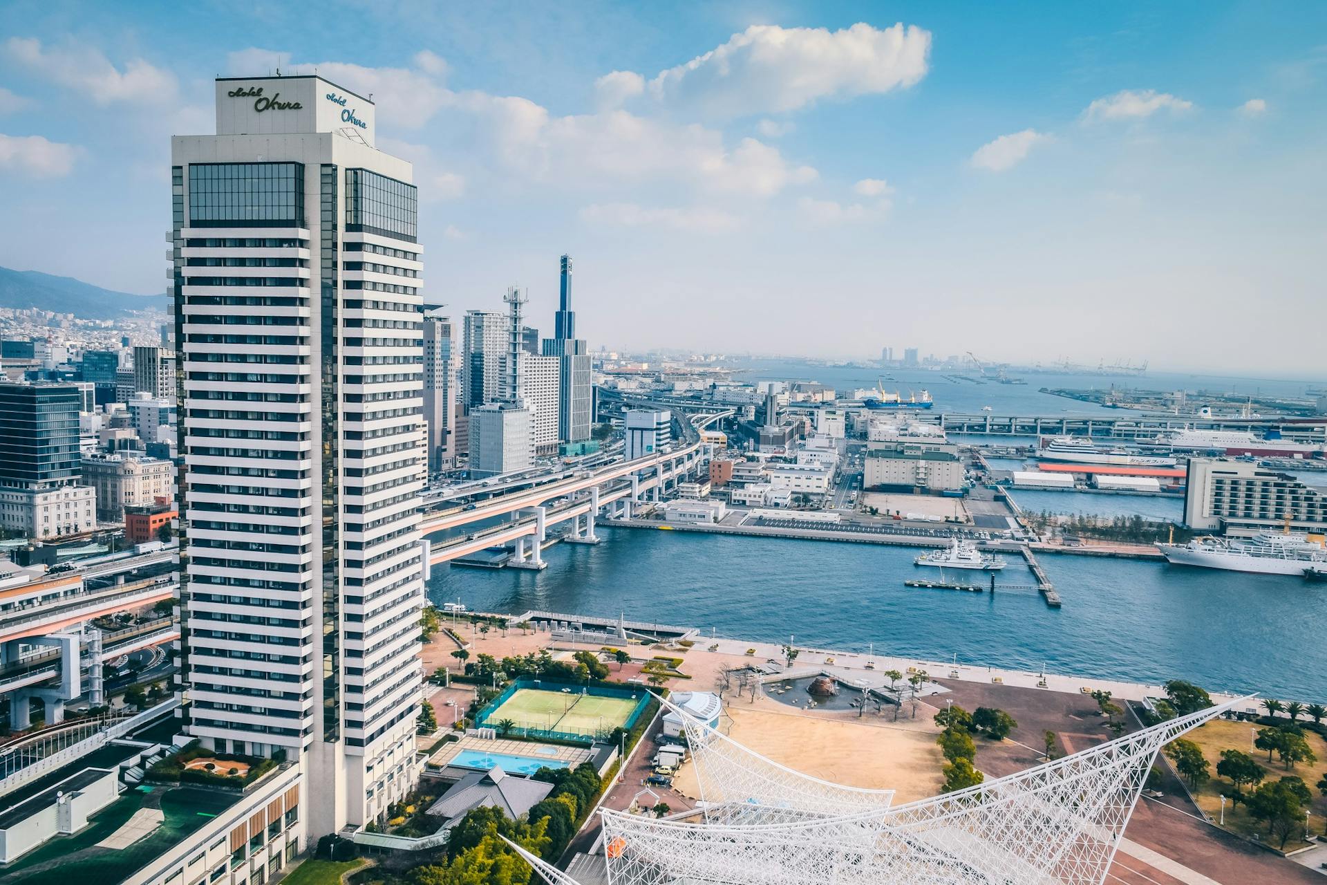 Elevated view of Kobe cityscape featuring modern architecture along the waterfront.