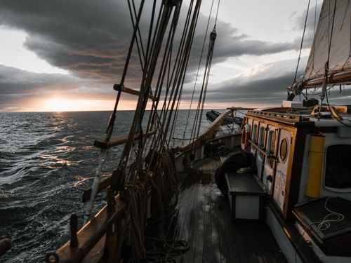 Free Amazing view of beautiful sunset over wavy sea from deck of wooden sailboat against dramatic sky Stock Photo