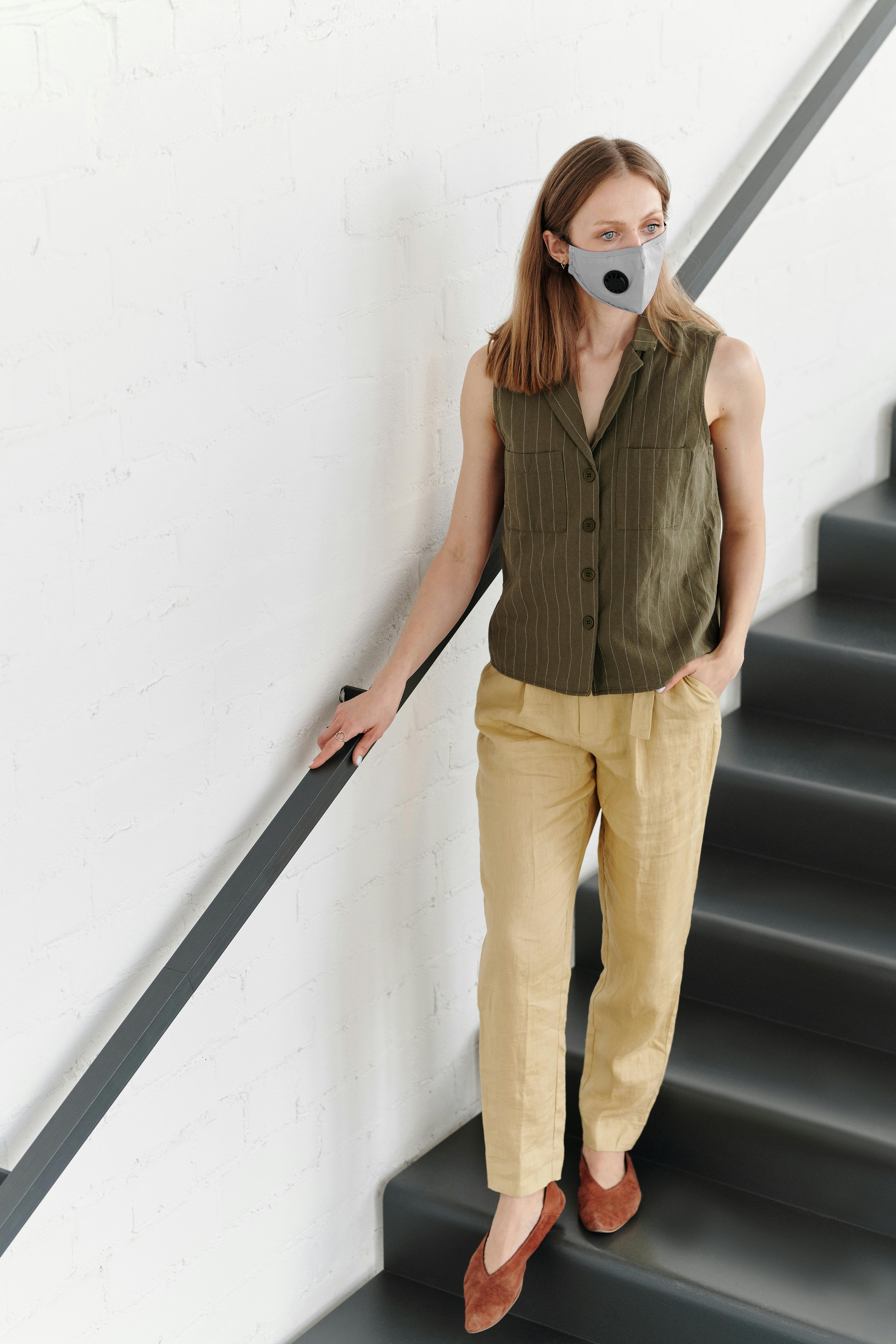 woman with a face mask on stairs