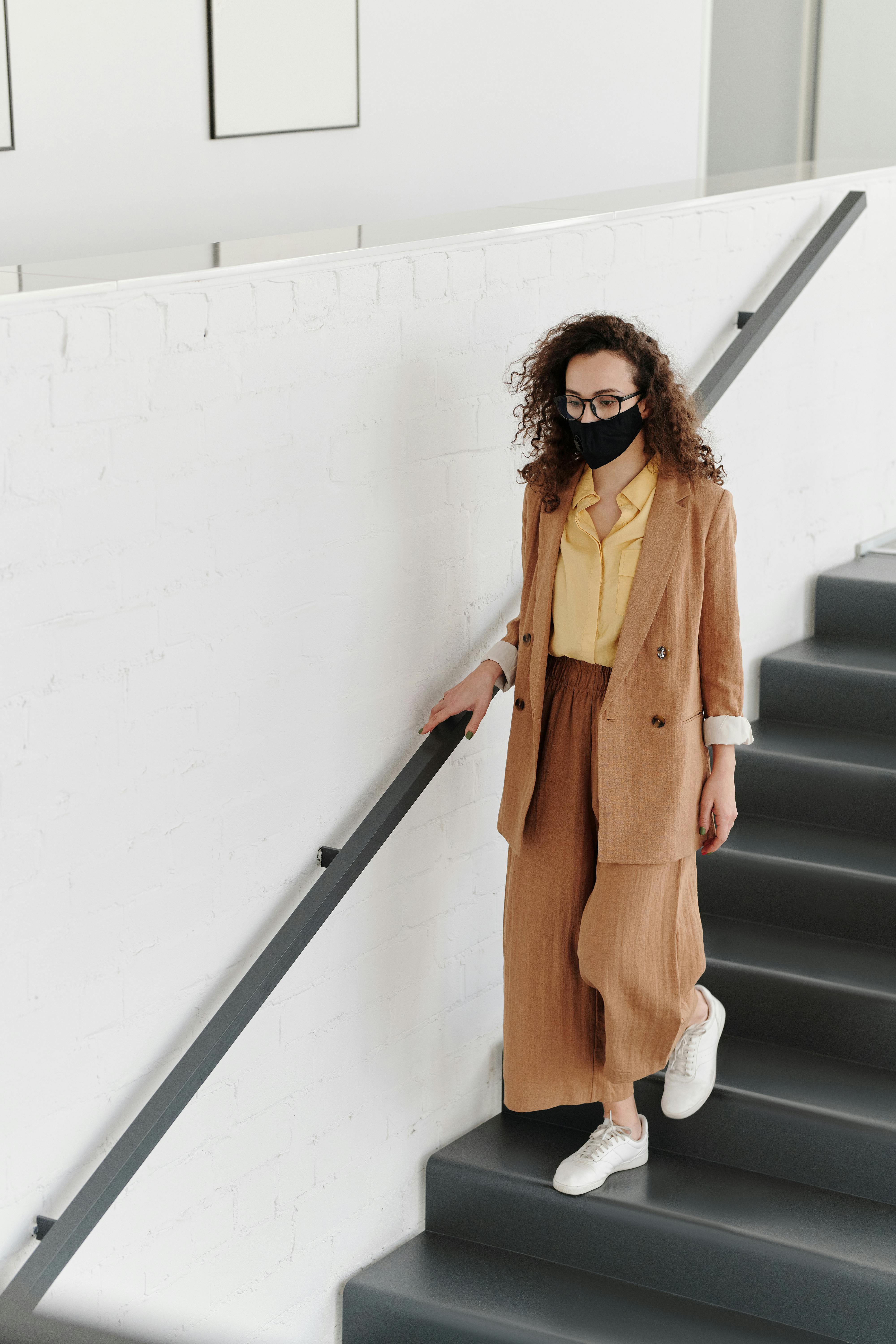 woman wearing a face mask walking down stairs