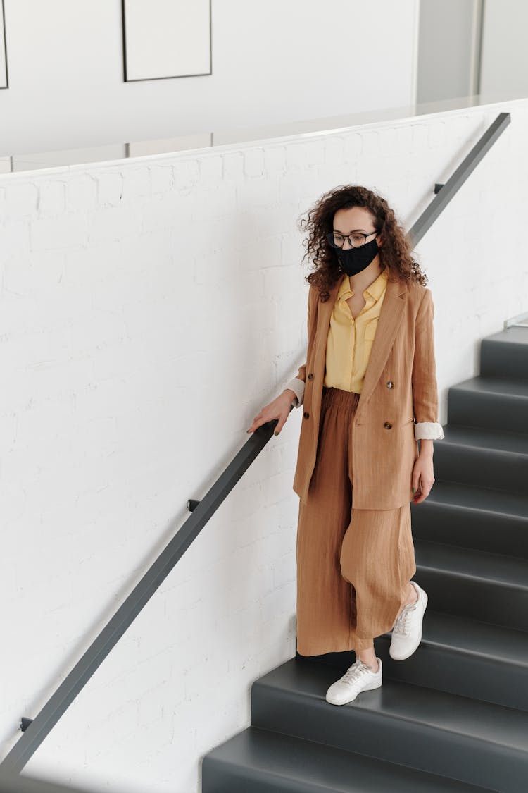 Woman Wearing A Face Mask Walking Down Stairs