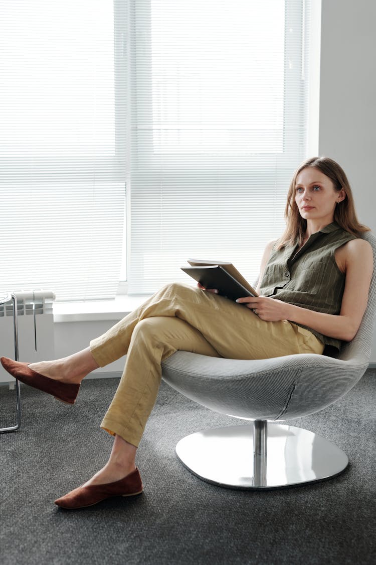 Businesswoman Sitting In Chair And Holding Documents