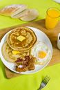 Delicious breakfast with pancakes and fried egg near fresh juice