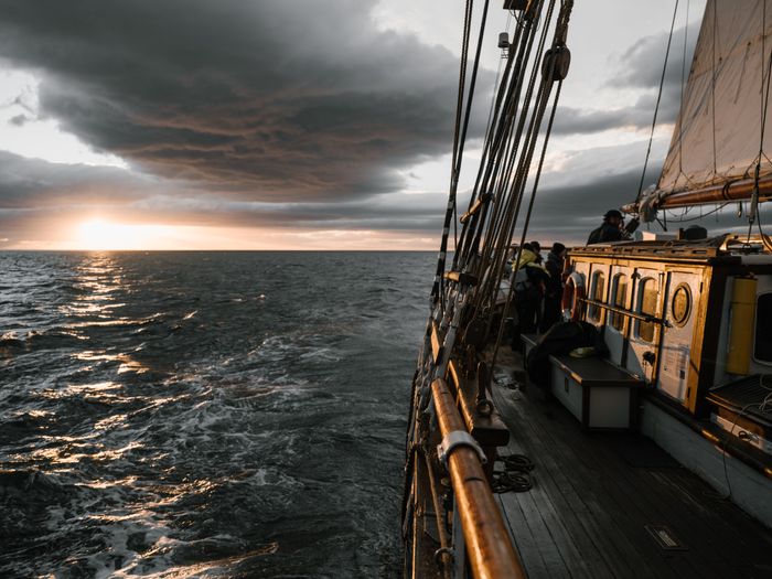 Wooden ship sailing at sunset
