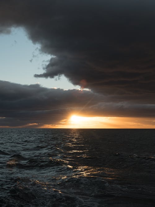 Cloudy sky over rippling sea during sundown