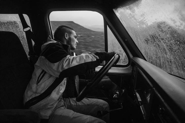 Young Man Driving Car During Snowfall