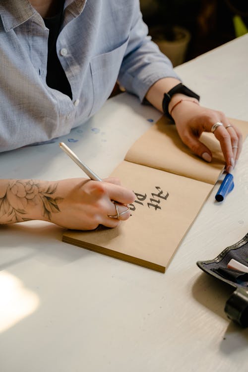 Person Writing on Brown Paper