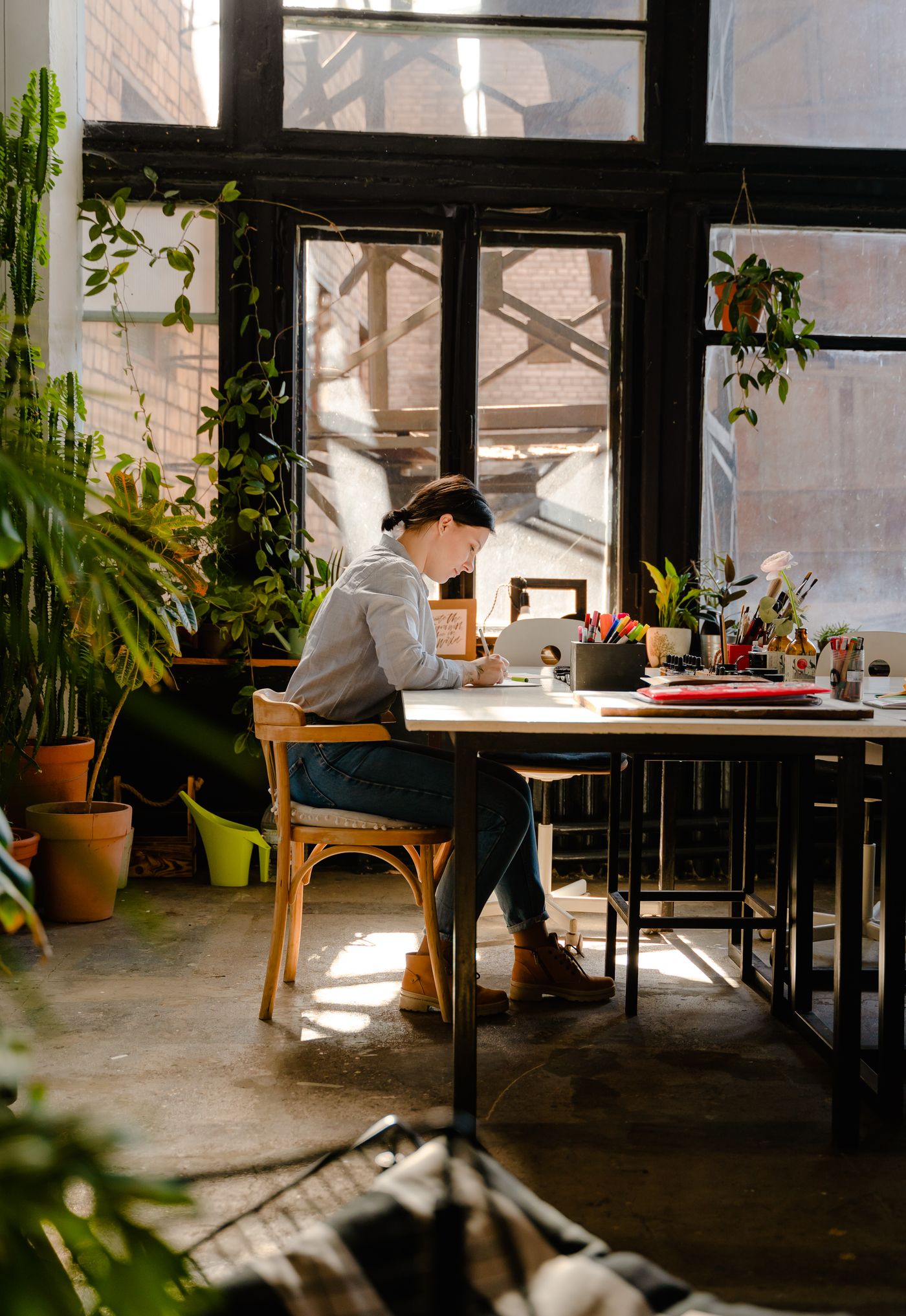An educator writing at a table in daylight