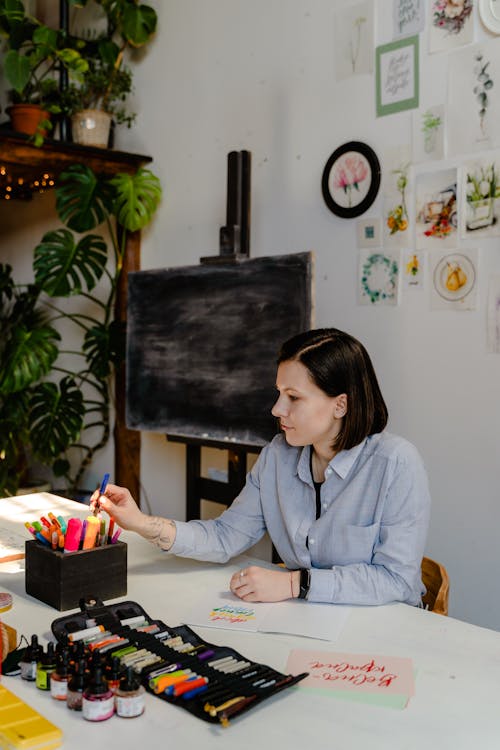 Photo Of Woman Picking Up Colored Marker Pens 