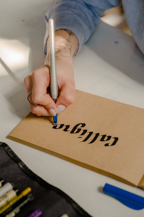 Person Writing on Brown Paper