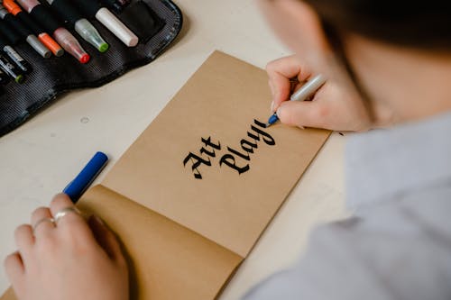 Person Writing on Brown Paper