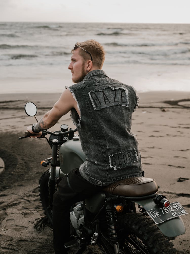 Young Man Sitting On Motorbike Near Ocean