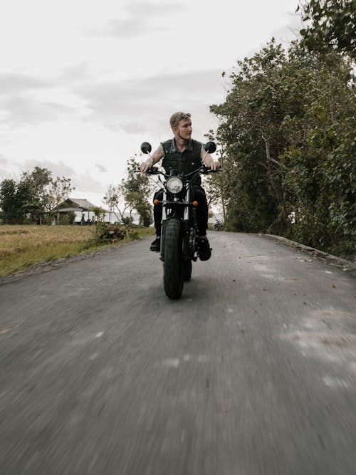 Man Riding Motorcycle on Road