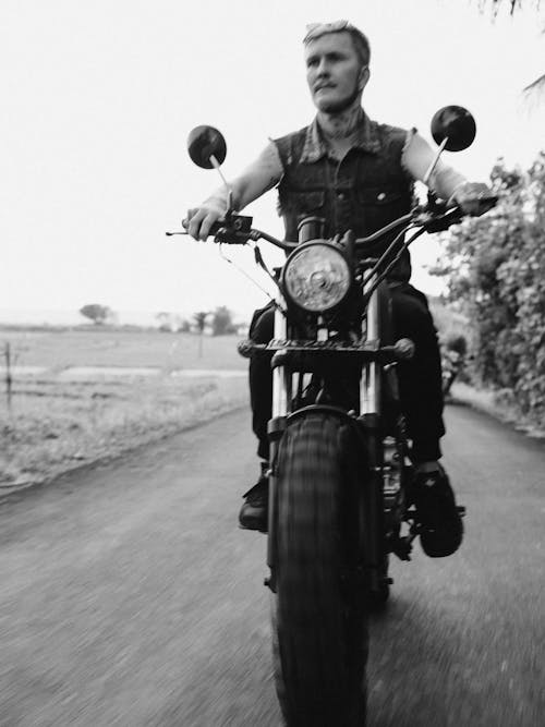 Grayscale Photo of Man Riding Motorcycle